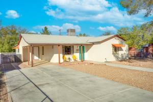 ein kleines weißes Haus mit Auffahrt in der Unterkunft Centrally Located Tucson Home with Fenced-In Yard! in Tucson