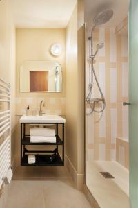 La salle de bains est pourvue d'un lavabo et d'une douche. dans l'établissement Edgar Suites Lille - Faidherbe, à Lille
