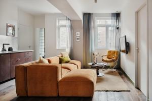 uma sala de estar com um sofá e uma cadeira em Edgar Suites Lille - Faidherbe em Lille