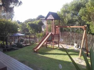 un parque infantil con un tobogán en un patio en Posta Cangrejo Apart en Las Gaviotas