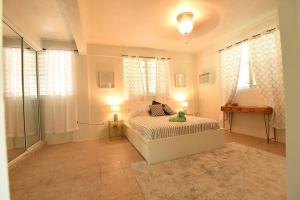 a bedroom with a bed with two lamps and a window at One Bedroom Apartment, Private pool, huge yard in Anasco