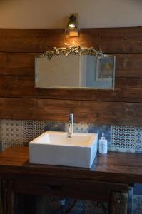 lavabo blanco en una encimera de madera con espejo en nuit romantique de retour de Chine, en Aubigny-sur-Nère