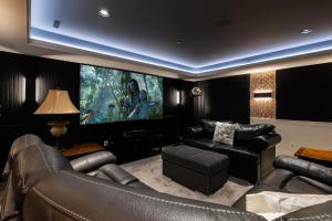 a living room with leather furniture and a large painting at Vancouver Golf Villa - Private Oasis in Vancouver