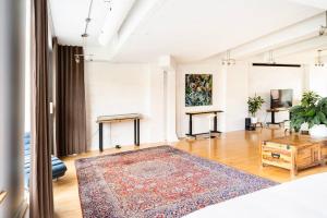 a living room with a rug on a wooden floor at MileEnd - Huge Bright & Modern Loft Suite - KingBed in Montréal