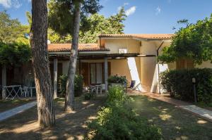 a house with trees in front of it at Pozzo al Moro Village in Marina di Campo