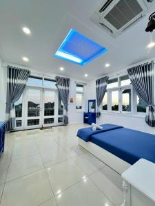 Ấp Phú Tịnh (2)にあるVilla Near the Beach 5 Bedrooms pe24のベッドルーム(青いベッド1台、大きな窓付)