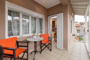 an apartment balcony with a table and chairs and windows at Cristina Apartment 2 in Neos Marmaras