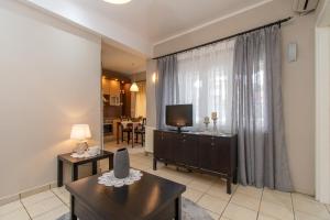 a living room with a television and a couch and a table at Cristina Apartment 2 in Neos Marmaras