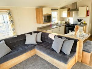 a living room with a couch and a kitchen at Seaside Escape at Trecco Bay in Porthcawl