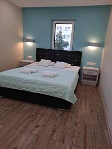 a bedroom with a large bed with two pillows on it at Helios Apartamenty in Ustka