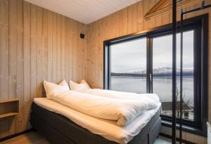 una camera da letto con un grande letto con una grande finestra di Luksus panorama hytte -H25 a Mestervik