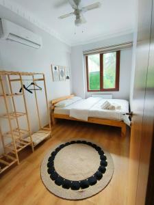 een slaapkamer met een bed, een raam en een tapijt bij Ihlamur Konağı in Sapanca