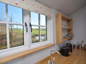 una cucina con due finestre, un lavandino e un bancone di 1 bed in Uplowman 60112 a Uplowman