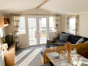 a living room with a couch and a table at Seaside Escape at Trecco Bay in Porthcawl