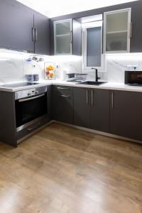 a kitchen with black cabinets and white counter tops at PANORAMIC SUITE in Athens