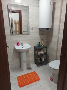 uma casa de banho com um lavatório, um WC e um espelho. em Relax in Apartment Stela em Skopje