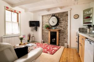 a living room with a fireplace and a couch at Portloe Cottage Padstow in Padstow
