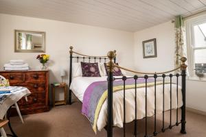 a bedroom with a black bed and a mirror at Portloe Cottage Padstow in Padstow