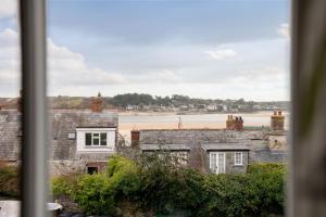 a view from a window of an old house and the beach at Portloe Cottage Padstow in Padstow