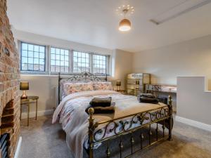 ein Schlafzimmer mit einem Bett und einer Ziegelwand in der Unterkunft 3 bed in Cromford 78591 in Cromford