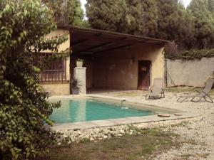 uma piscina num quintal com uma casa em Maison Plan-d'Orgon, 4 pièces, 7 personnes - FR-1-767-4 em Plan-dʼOrgon