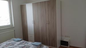 een slaapkamer met een bed en een grote houten kast bij Smjestaj_S in Bijeljina