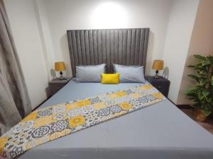 ein Schlafzimmer mit einem großen Bett und einem gelben Kissen in der Unterkunft Luxury one bed Apartment in Gold Crest Mall And Residency DHA Lahore in Lahore