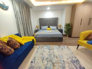 a bedroom with a bed and a blue couch at Luxury one bed Apartment in Gold Crest Mall And Residency DHA Lahore in Lahore
