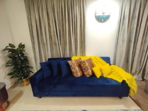 um sofá azul com almofadas na sala de estar em Luxury one bed Apartment in Gold Crest Mall And Residency DHA Lahore em Lahore