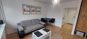 a living room with a couch and a table at Apartament Koszutka - 100m od Spodka in Katowice