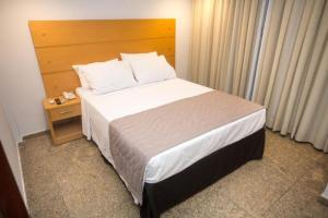 Un dormitorio con una cama grande con cabecero de madera. en Regency Copacabana Hotel, en Río de Janeiro 50 fotos más