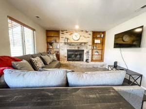 een woonkamer met een bank en een open haard bij Family Retreat near USAFA / Firepit/Games/Grill in Colorado Springs