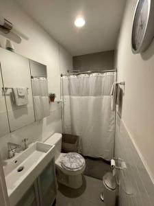 a white bathroom with a toilet and a sink at Modern 1-bedroom in Manhattan-New York, NY in New York