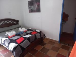 1 dormitorio con 1 cama con manta blanca y negra en AZULEJO, en Jericó