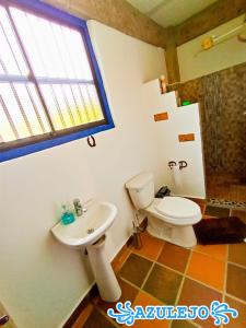 ein Bad mit einem WC und einem Waschbecken in der Unterkunft AZULEJO in Jericó