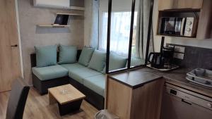 a living room with a couch in a small room at Les Dunes de Contis in Saint-Julien-en-Born
