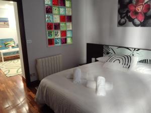 ein Schlafzimmer mit einem weißen Bett und Handtüchern darauf in der Unterkunft Apartamento Etxe Morea, Casco Histórico in Bermeo