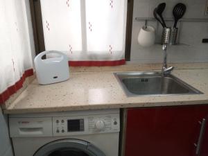 a kitchen with a sink and a washing machine at Apartamento Etxe Morea, Casco Histórico in Bermeo