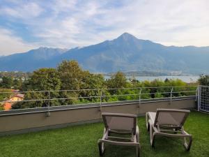 two chairs on a balcony with a view of the mountains at Vigna Panorama in Gera Lario
