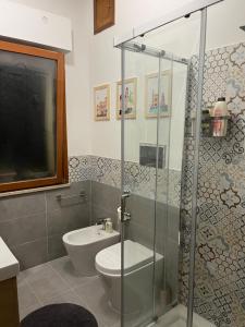een badkamer met een toilet en een glazen douche bij La Locanda del Cedro in Palermo