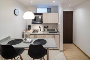 a kitchen with a counter with chairs and a table at Anima 64 in Bogotá