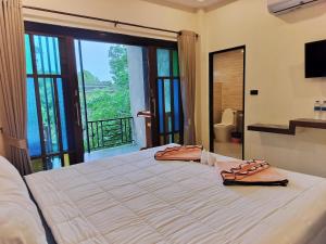 a bedroom with a large bed with two towels on it at The Zohan Resort & Travel Agency in Wok Tum