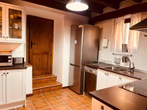 a kitchen with a refrigerator and a sink at Villa Revolcona in La Adrada