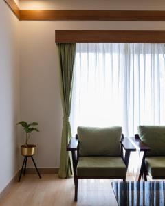 sala de estar con sofá y ventana en Malnad Shire Eco Resort, en Shimoga