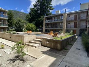 une cour d'un bâtiment avec un banc et un bâtiment dans l'établissement Alamos de los Andes ExtraL - Andarlibre, à San Martín de los Andes