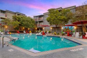 una piscina en un hotel con sillas y sombrillas en Aiden by Best Western Austin City Hotel, en Austin