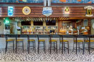 a bar with stools in front of a bar at Aiden by Best Western Austin City Hotel in Austin