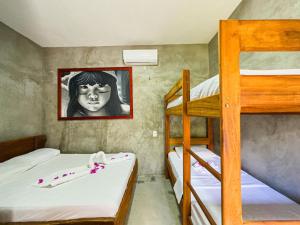 a bedroom with two bunk beds and a painting of a girl at Pousada Cavalo Bravo Preá Jeri in Prea