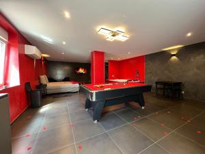 a red room with a pool table and a bed at Le Confiden'spa Loft 55m2 Jacuzzi - Billard - Cheminée - Terrasse in Hoenheim