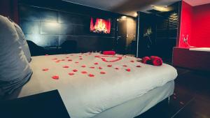 a room with a bed with red rose petals on it at Le Confiden'spa Loft 55m2 Jacuzzi - Billard - Cheminée - Terrasse in Hoenheim